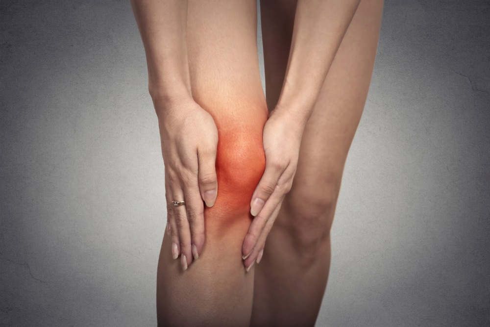 A close-up shot of a person’s knee, which is red and inflamed because they need a revision knee replacement.