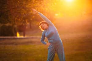 Woman stretches at sunset after hip replacement in Lake Oswego, OR