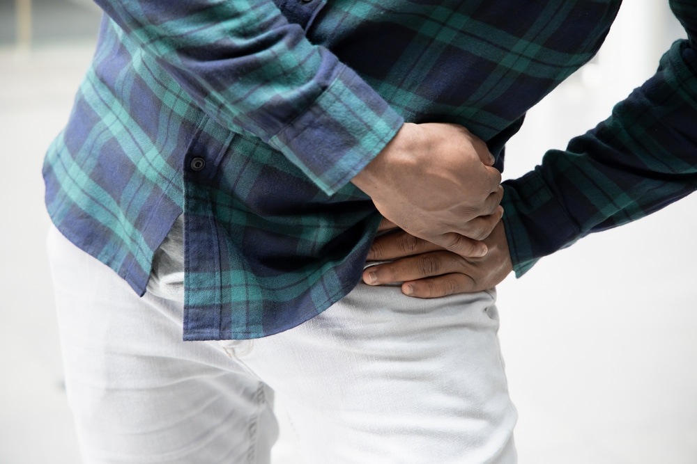 A cropped shot of a man holding his hip